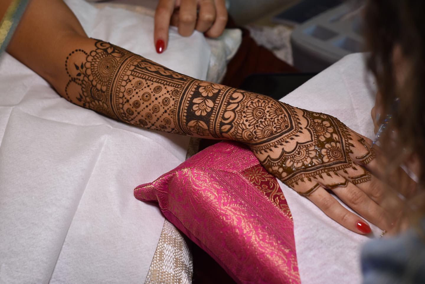 Detailed henna sleeve being applied for an event