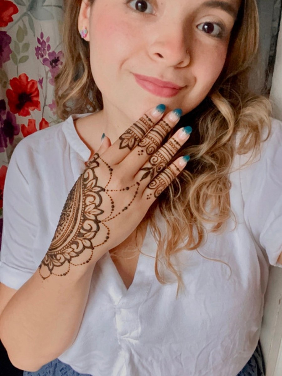 Mafe applying henna to a client